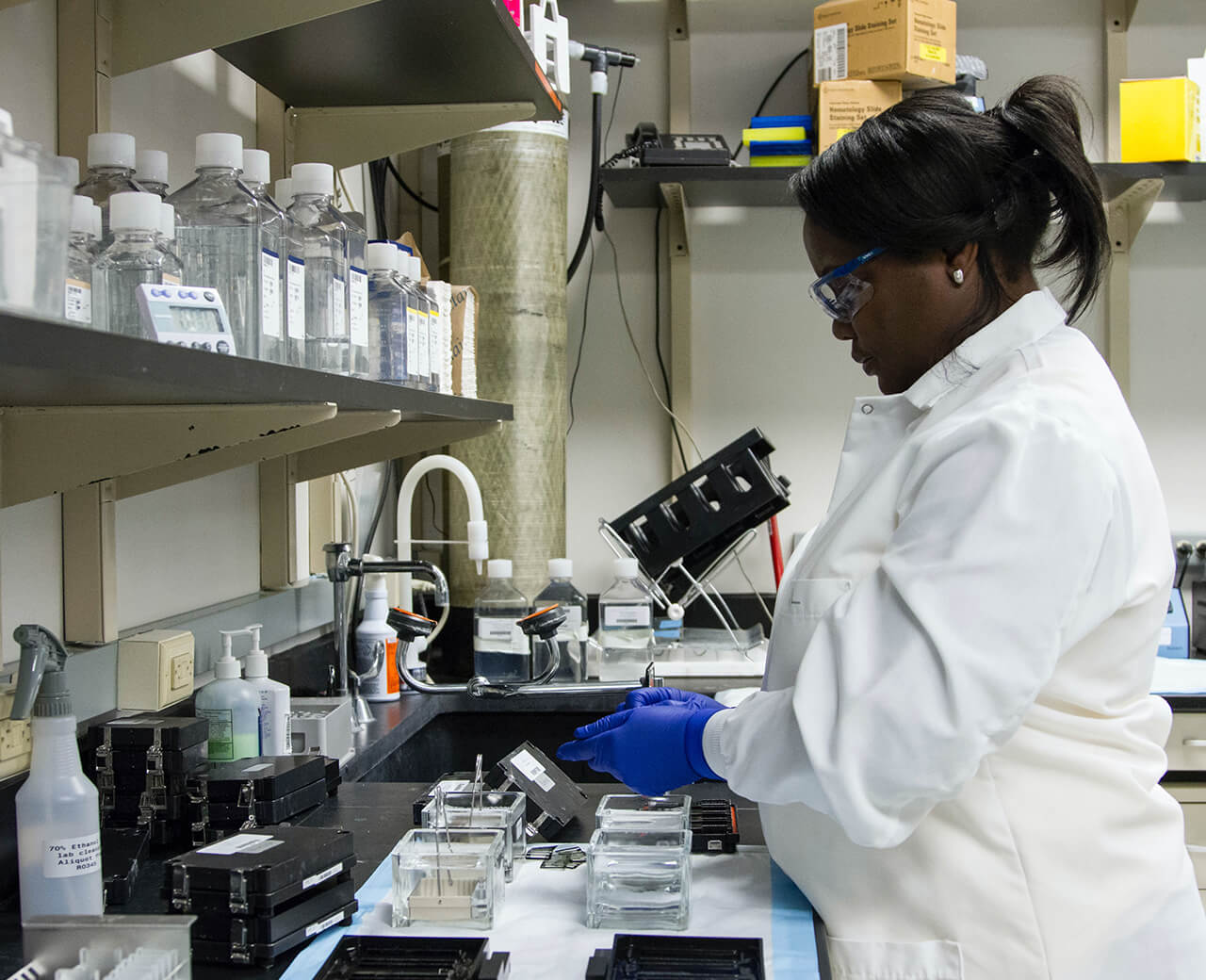 Jazz Pharmaceuticals employee wearing a white lap coat while working in a lab