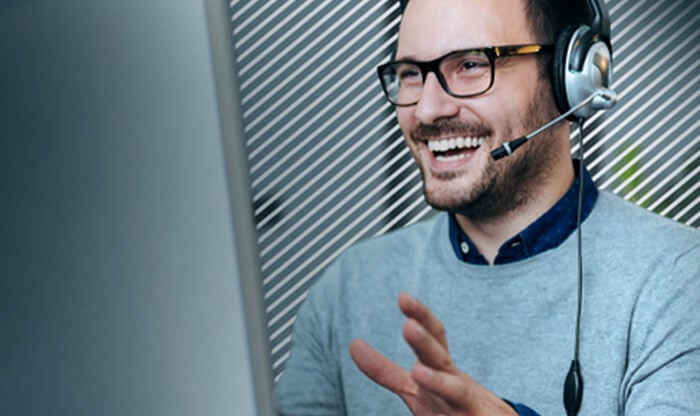 Employee with headset working on large monitor