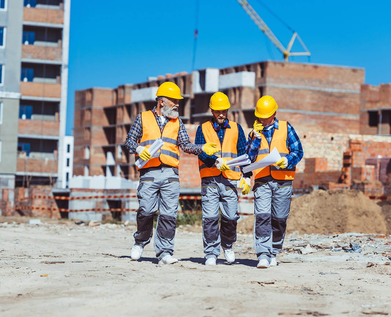 3 Rydon employees in safety gear walking on a construction site