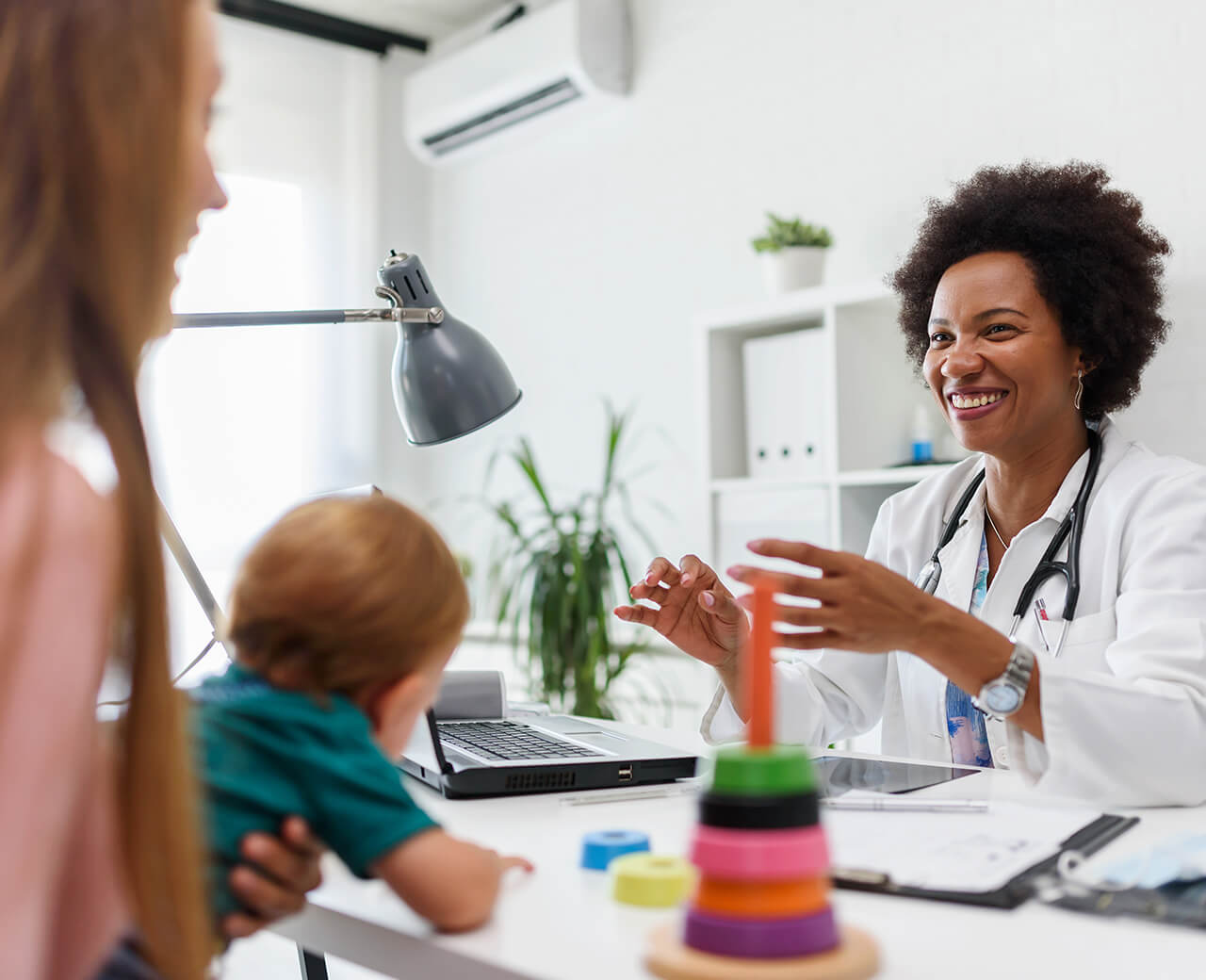 A doctor meetings with a mother and young baby