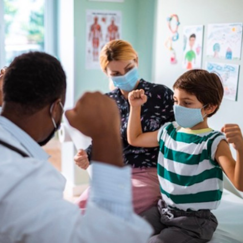 CommonSpirit doctor encourages young patient to flex his arms