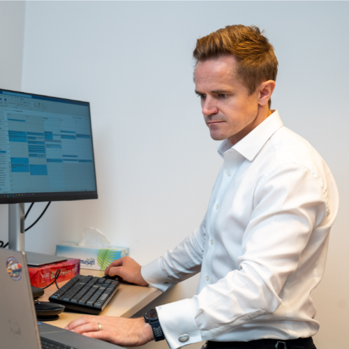 KEO employee works at a standing desk