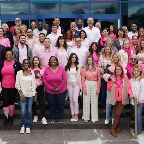 Konica Minolta employees pose for a picture after a breast cancer awareness event.