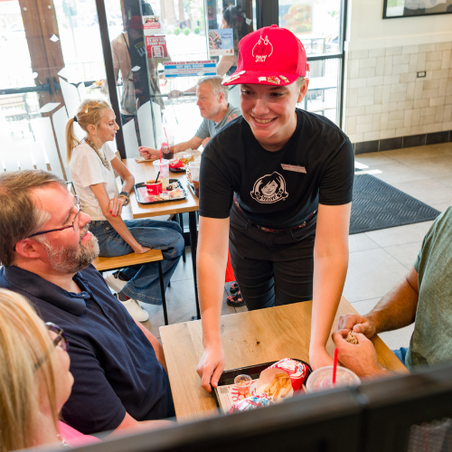 Wendy's employee brings out tray of food in one of their restaurants.
