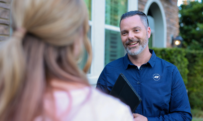 ADT employee speaks with customer outside her home