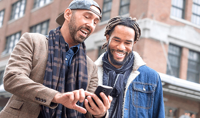 male friends looking at phone screen and laughing
