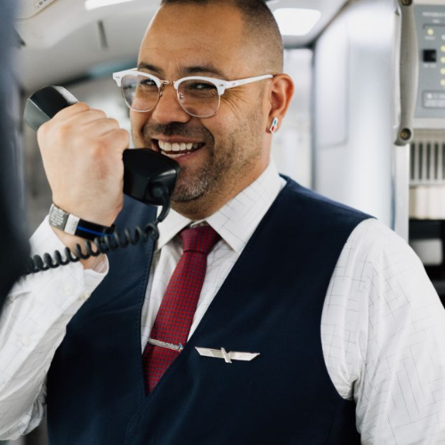 PSA Airlines flight attendant speaks into the phone